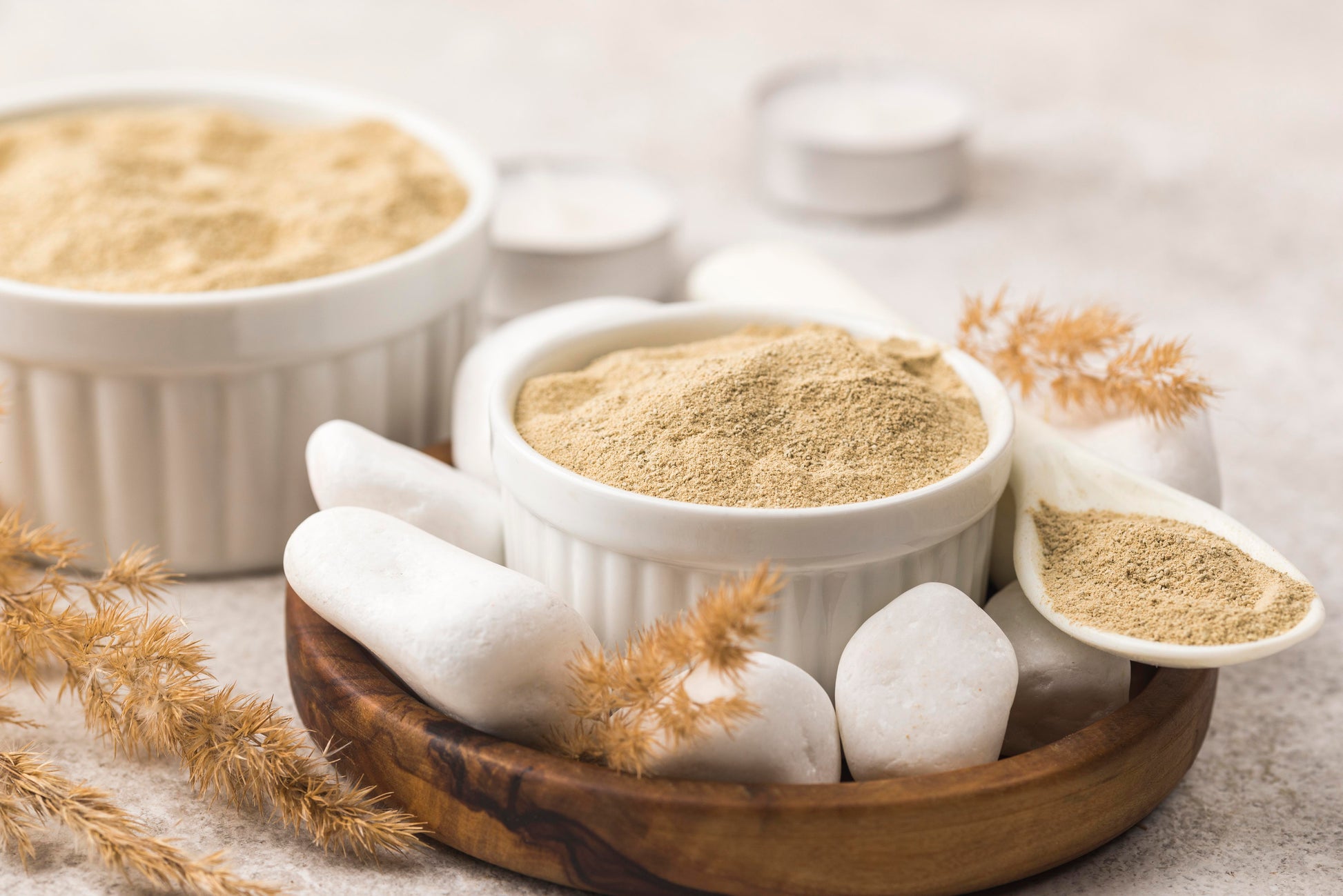Bowls of powder on a neutral background with decorative elements